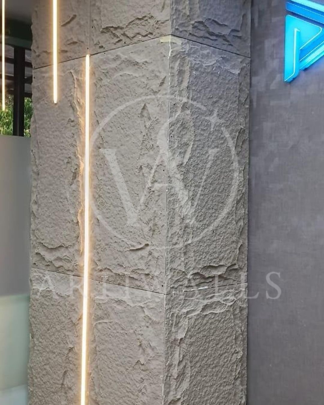 Kolom interior dengan panel bertekstur putih dan lampu vertikal